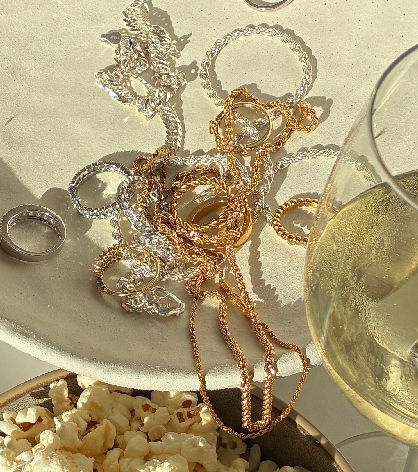 Gold and sterling silver jewelry on a decorative bubbled white surface